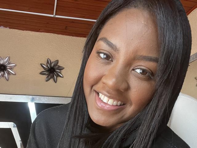 TiffanySammy a la peau brun foncé, de longs cheveux noirs et lisses, et elle sourit en montrant ses dents blanches. Elle porte un haut noir, a les yeux marron et ne porte pas de maquillage. Ses fesses ne sont pas visibles..