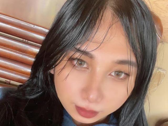 SereiaRedfield has black hair, brown eyes, and a slight smile. She's looking at the camera with a soft, natural expression. Her makeup is minimal, highlighting her natural beauty.