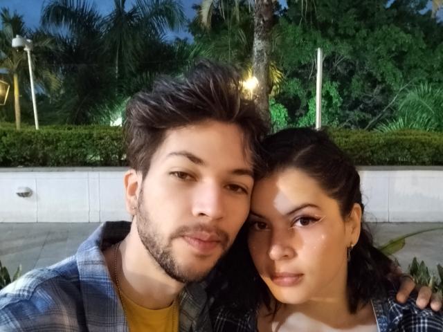 HottersTeam has a cute, cute ass, and a cute face, standing with HottersTeam who has dark hair, a pretty face, and is wearing a plaid shirt.