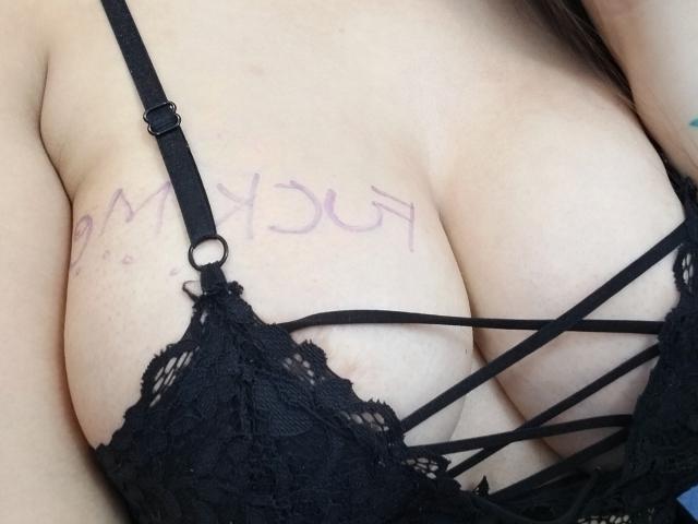 De grote borsten van AnnyCraffort zijn te zien in een zwarte kanten BH met bandjes, waarbij haar bleke huid vage paarse letters op haar borst onthult. Haar borsten zijn duidelijk zichtbaar..