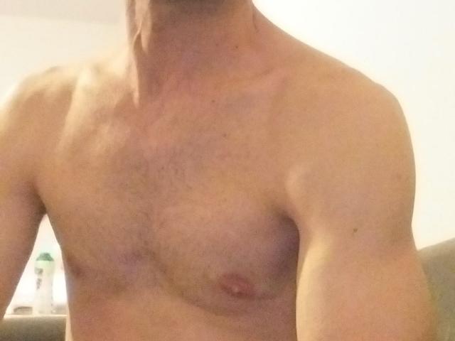 Ledjee's bare, muscular chest with small, pink nipples and a slight tan. His arms are slightly visible, and his neck is cut off from the frame.