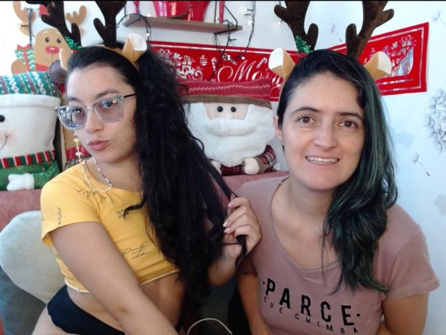 LunaVenus with curly black hair, glasses, yellow crop top, black panties, and reindeer antlers, next to LunaVenus with green hair, pink shirt, smiling. Both have cute faces.
