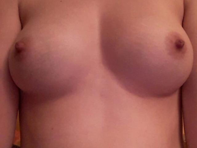 Spielzeuglena-hot's bare boobs, small to medium in size, with light skin and pink nipples, centered in the image. Her flat chest is visible, no clothes.