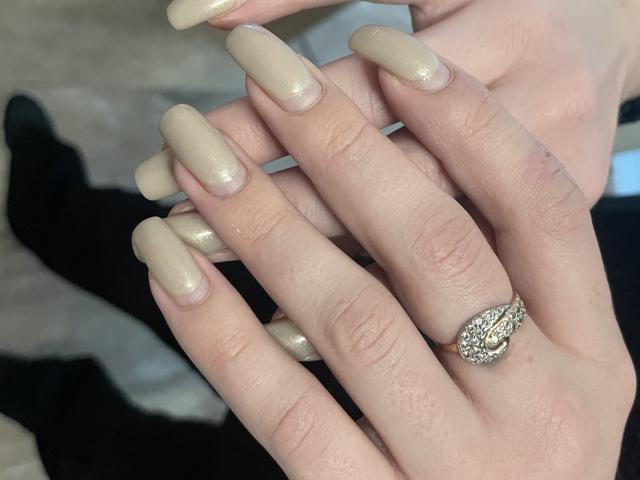 Les mains de Vailett, avec de longs ongles brillants et beige, portaient une bague ornée d'un groupe de petits diamants sur l'annulaire. Sa peau est claire et ses ongles sont lisses..