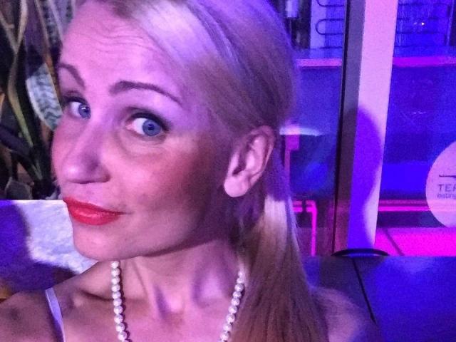Leilani69-hot ha i capelli biondi, gli occhi azzurri, il rossetto rosso e indossa una collana di perle, guardando la fotocamera con un leggero sbuffo. Ha il seno piccolo ed è carina..
