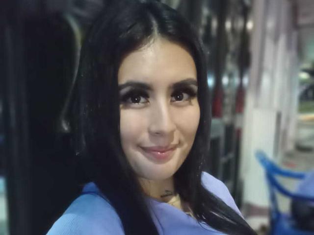 AlisonKweel has dark, straight hair and a subtle smile, wearing a blue top, with brown eyes and glossy pink lips. Her face is centered, looking slightly to the right.