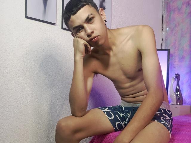 Graphic design of a stylized, cut-out letter "A" in bold, dark color with a lighter, blurred interior. Simple, flat composition with no gradients or textures. Minimalistic.