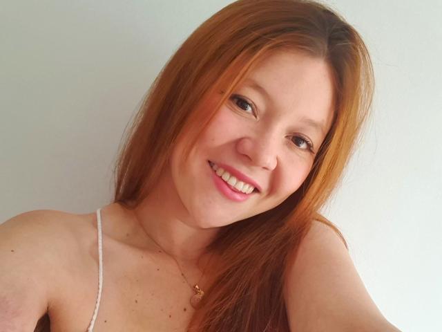 EuphoriaRush a les cheveux roux, une peau claire et un sourire mignon avec des lèvres roses. Elle porte un bandeau blanc, qui révèle ses petites seins fermes. Son collier a un petit cœur..