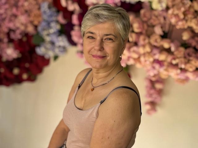 Digital illustration of a stylized medieval-style coat of arms. Bold, flat colors with soft edges. Central, large, overlapping letters in red and blue. Simple, geometric design. Minimal shading.