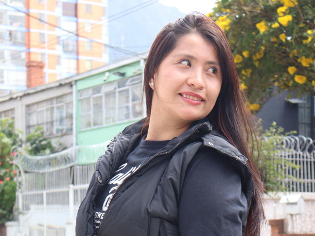 AshleyWalkerI has long brown hair, a black puffy jacket, and a black shirt, smiling slightly, with a cute, round face and small nose, in a sunny outdoor setting.