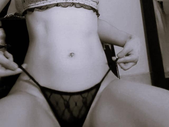 HarlyMia's lower belly and crotch in black, sheer panties with a diamond pattern. She's pulling the sides, showing a small navel and a slightly visible pussy. Monochrome image.