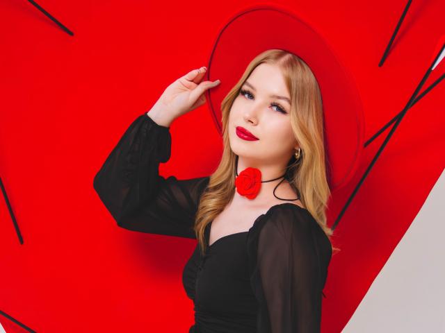 NicoleBrian with blonde hair, red lipstick, black sheer dress, red rose choker, and matching red hat, holding hat, looking at camera, sexy, pretty, red background, black lines.