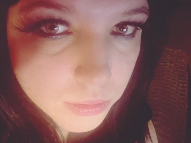 LulaJanet's face, showing her pinkish lips and brown eyes with long lashes, has a slightly flushed complexion and dark brown hair framing her face.