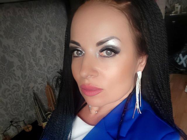 EmillySun-hot with dark braids, silver eyeshadow, blue jacket, diamond earrings, nose piercing, and pink lipstick, showing off her sexy face and subtle makeup.
