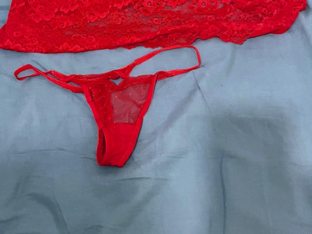 Red lace lingerie set with a sheer red thong and lace top, laid on a blue fabric. Thong is positioned lower, lace top upper. IceLoveFire's panties.