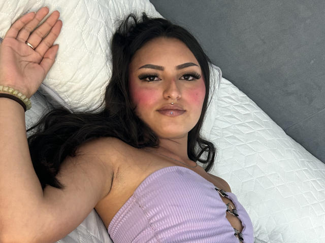 Digital illustration of a flat, geometric-style logo with a bold, red "B" in the center. The logo has a white, ribbon-like pattern below the "B". Soft, gradient colors.