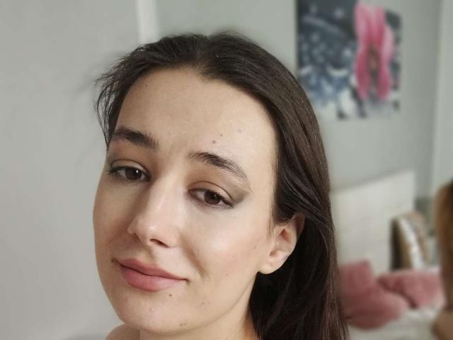 JuliaHuntis ha un viso carino, con occhi marroni, un trucco leggero e un sorriso appena accennato. Ha i capelli castano scuro e una piccola lentiggine sulla guancia destra..