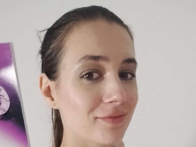 JuliaHuntis has a fair skin tone, brown eyes, and wet, slicked-back dark brown hair. She's smiling with a slight pinkish nose and subtle freckles.