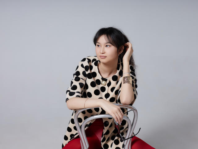 Flower-shaped logo with bold black and red accents. Stylized, abstract design with curved petals and a central black dot. Minimalist, modern aesthetic. White background. Simple, clean lines.