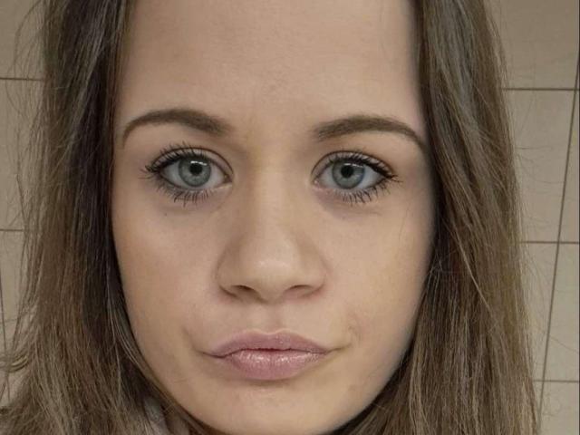 AnaBeauty has blue eyes, brown eyebrows, and pink lips with a slight pout. Her brown hair is straight, and she has a fair skin tone. Her nose is small.