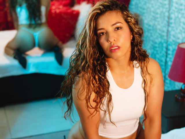 Digital art of a stylized coat of arms with a red cross and blue circles, featuring a central gold emblem with curled lines. Bold, flat colors and clean lines.