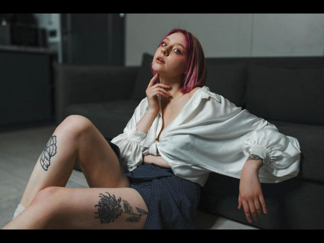 Minimalist illustration with flat colors, featuring a large, stylized red and white emblem at the center. Simple, bold shapes and clean lines dominate the composition. Madeline-Extasy is not present.