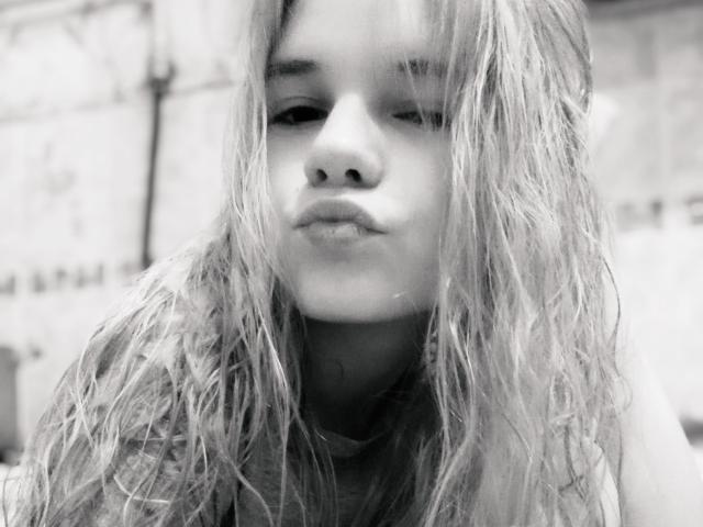 Black-and-white photo of MandyBrooks with wet, messy blonde hair, pouty lips, and a slightly annoyed expression, wearing a dark shirt, showing her nose and mouth.