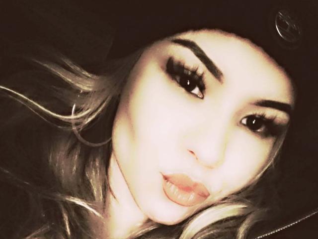 NativSBeauty has pouty lips, full eyelashes, and thick eyebrows, wearing a black hat. Her blonde hair is slightly visible, and she has a fair skin tone.