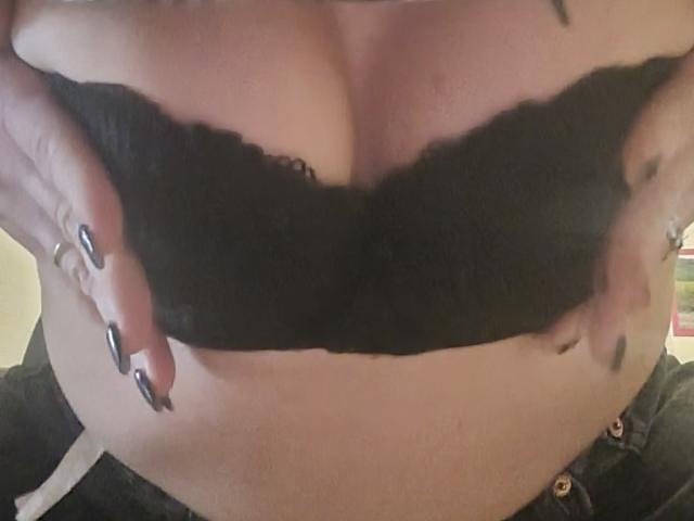 SeleneStar69's big, black lace bra is being held up by her hands with long, black-painted nails. Her pale skin is visible above the bra and below the lace.