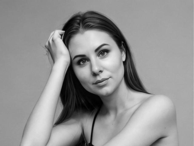 FrostxAngel with long dark hair, raised arm, and a slight smile, looking directly at the camera, showing her bare shoulders and subtle makeup in a black-and-white photo.
