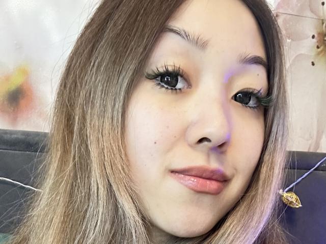 RenyLime tiene el cabello castaño claro, ojos verdes con largas pestañas negras y labios rosados. Está sonriendo ligeramente y tiene un pequeño grano en la mejilla izquierda..