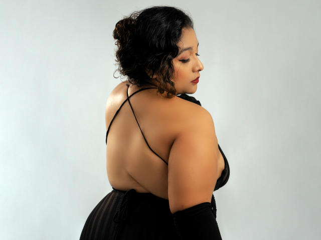 Simple art style, flat colors, minimalist design. Central object: large, orange-red, abstract, flame-like shape with black dot in upper right. White, rectangular background. No text or additional elements.