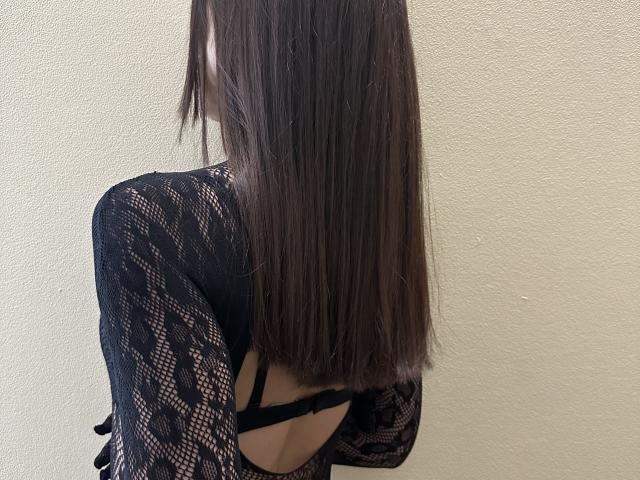 Stefanni's back is to the camera, showing her long brown hair and black lace top with an open back, revealing a black bra strap.
