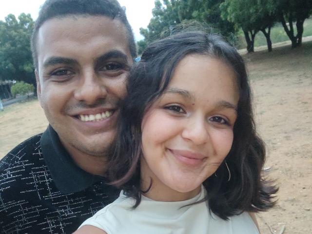 WildCoupleS has a chubby, dark-skinned dude with short curly hair and a black patterned shirt, and a cute, brown-skinned girl with wavy hair and a white shirt.