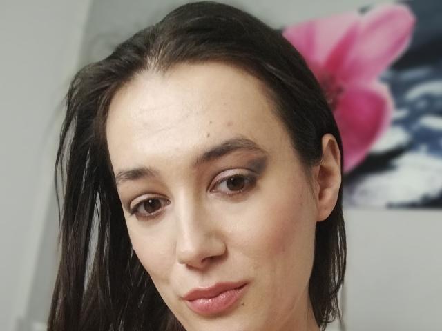 JuliaHuntis has dark brown eyes, straight black hair, and pink lips with a slight pout. She's got a few small moles on her forehead. Her ass is not visible.