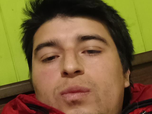 HotChileGuy has a chubby face with light brown skin, black spiky hair, and is pouting with slightly parted lips. He's wearing a red jacket with a brown collar.