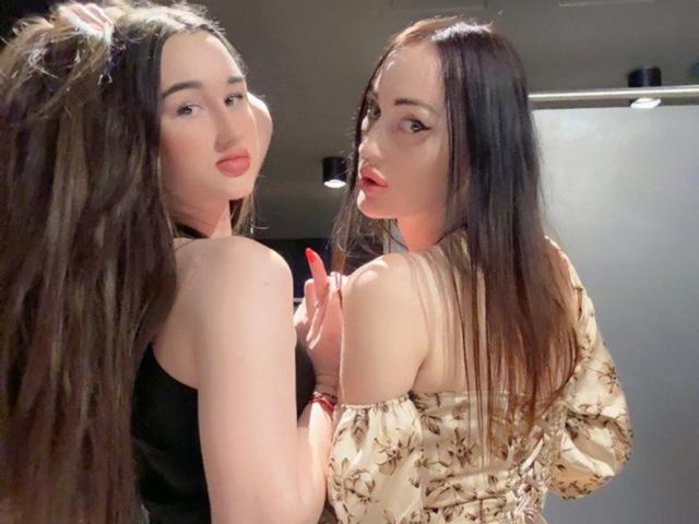 FortuneLisa69 has long brown hair, red lips, and wears black and floral off-shoulder tops. She's looking over her shoulder, showing her tits, with a slight pout.