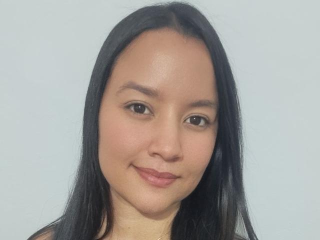 KathyHottie69 has medium brown skin, black straight hair, small brown eyes, thin eyebrows, and a subtle smile with light pink lipstick. Her face is centered, looking slightly to the left.