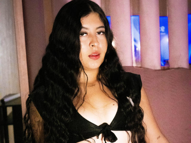 A 3D-style coat of arms with a blue vertical stripe in the top right corner and a smaller red vertical stripe in the bottom right. Soft, muted colors.