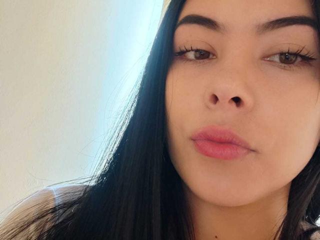 SophiaRamirez has long black hair, brown eyes, and pink lips, with a neutral expression, showing her nose and slightly parted lips. Her eyebrows are thick and well-groomed.