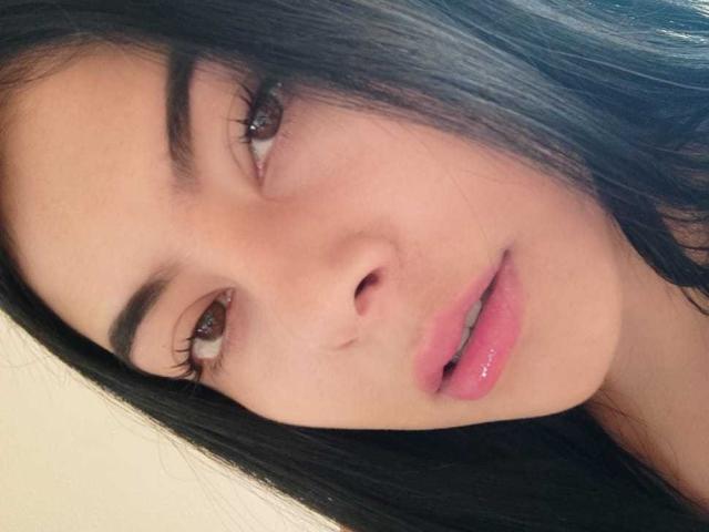 SophiaRamirez's face, showing dark straight hair, brown eyes, and pink glossy lips. Her skin is light brown, and she has a slightly open, sexy mouth. Her eyebrows are dark.
