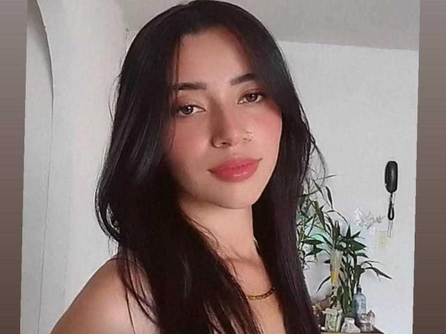 SophiiaFerrero a de longs cheveux noirs, des yeux marrons, et elle sourit avec des lèvres roses. Elle porte un collier en or et a un piercing au nez. Ses seins ne sont pas visibles..