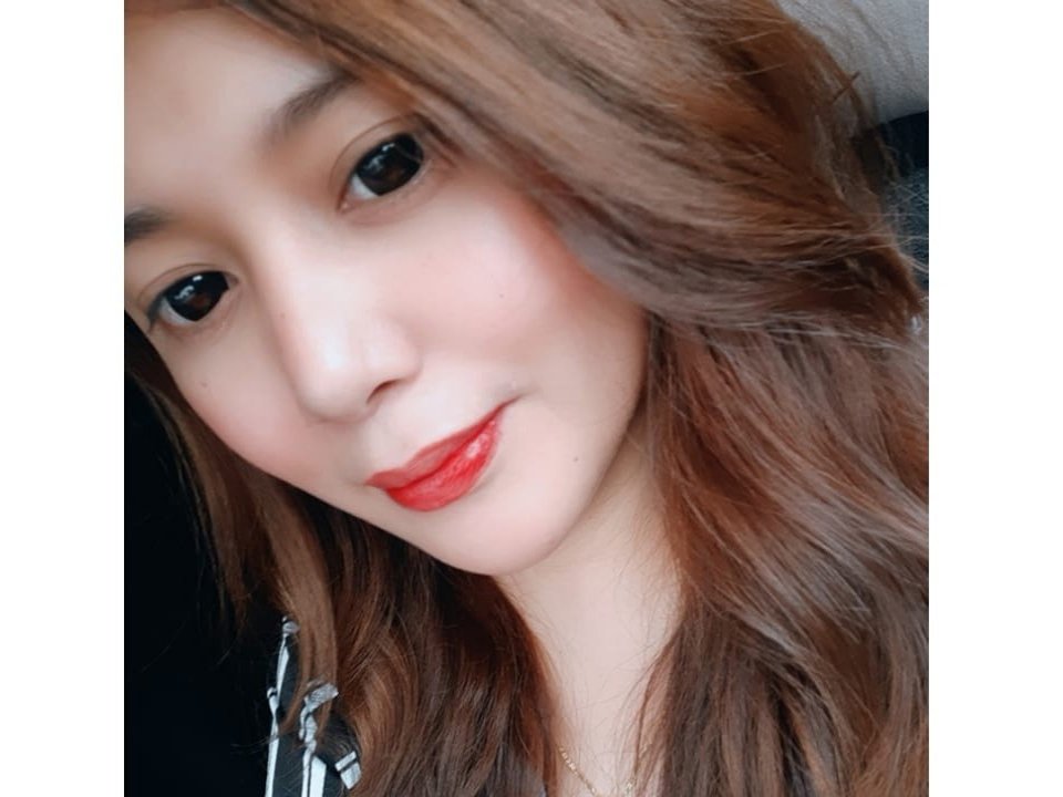 TheMistressTS69 a les lèvres rouges, une peau brillante et des cheveux bruns ondulés, avec des yeux noirs et un sourire discret. Ses fesses ne sont pas visibles sur cette photo..