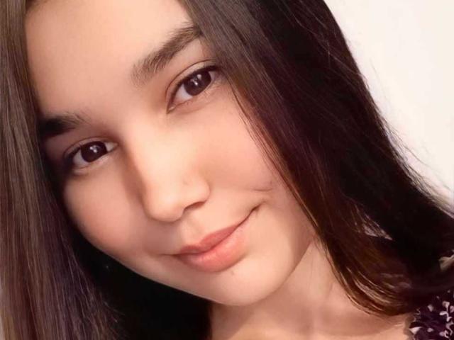 IvanaStaysi's face is in the photo, showing her brown eyes, straight brown hair, and a slight smile with her pink lips. She has a light skin tone.