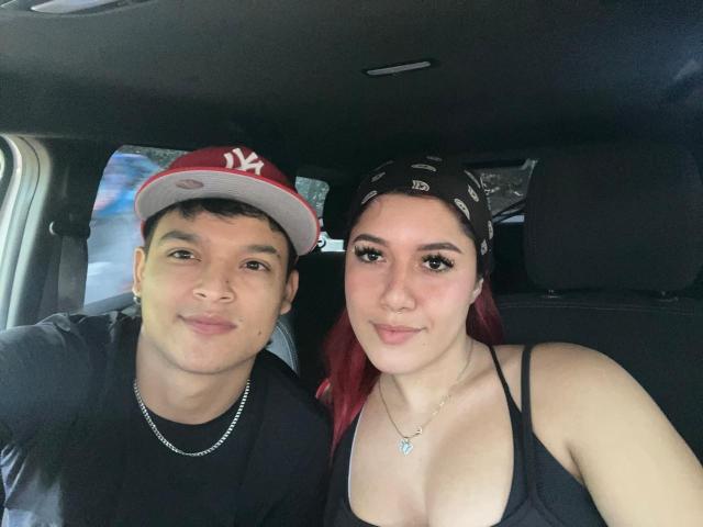 RosseRyan with a cute face, black shirt, and necklace, and RosseRyan with red hair, black bandana, and cleavage in a car, both smiling. He's wearing a NY cap.
