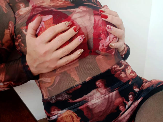 JaneTurner's hands with red nails and gold patterns cover her red, shiny boobs through a sheer, painted dress with classical art patterns. Her fingers grip her tits firmly.