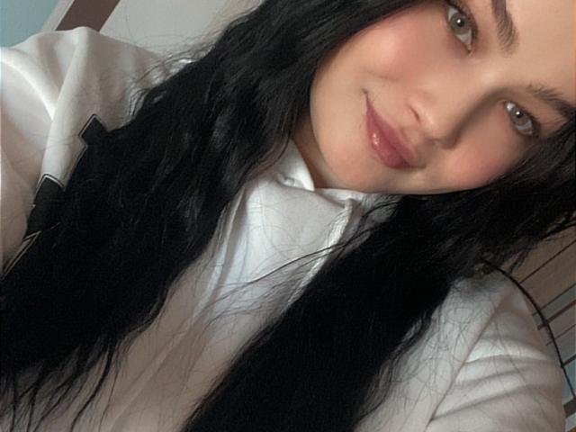 FortuneElizabeth tem cabelo preto e liso, olhos castanhos e um sorriso discreto. Ela está vestindo uma camisa rosa clara, e seu rosto tem um leve rubor rosado..
