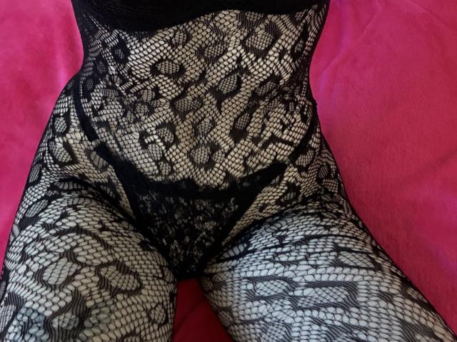 HappyTina's lace-covered pussy and thighs, black fishnet pattern, red background, legs spread, visible black lace panties, sexy and seductive.