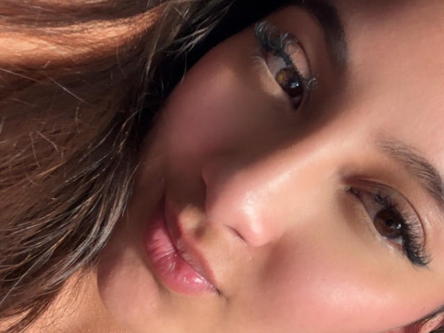 DianaFernandezz's face, showing brown eyes with long eyelashes, pink lips, and light brown skin, with brown hair partially visible. Her slightly pouty expression is centered in the shot.