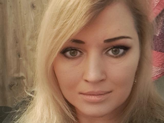 CamilleJazz has blonde hair, green eyes, and a slight smile with subtle makeup. Her nose is centered, and she's looking directly at the camera with a relaxed expression.